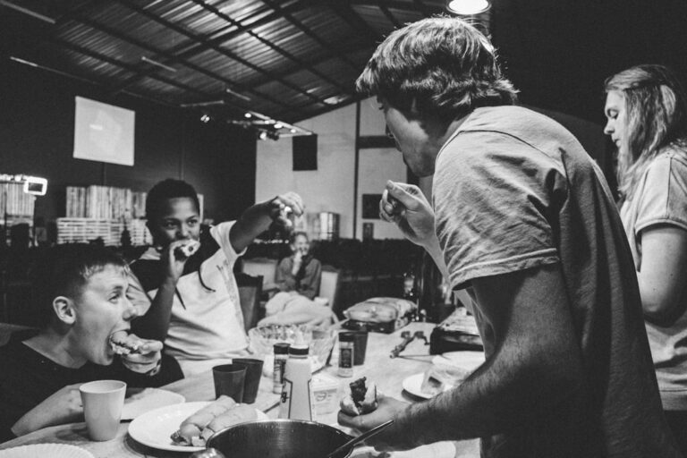 Groupe d'amis riant autour d'une table en soirée jeux