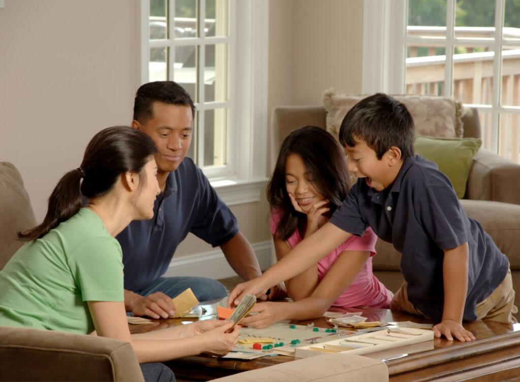Famille jouant à un jeu de société autour d'une table basse