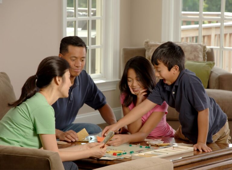 Famille jouant à un jeu de société autour d'une table basse